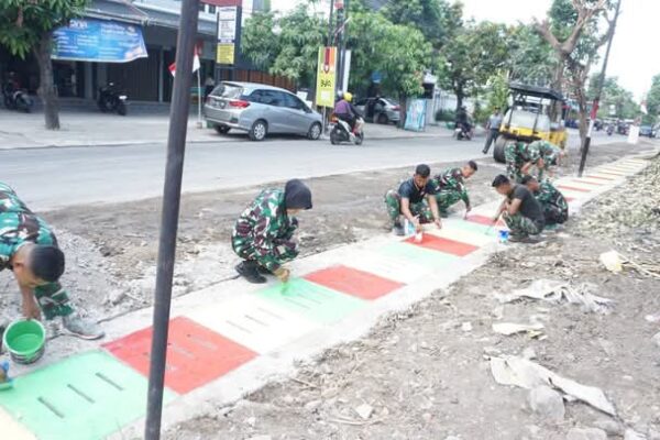 Guyub Rukun, Satgas TMMD Reguler Ke-125 Kodim 0735/Surakarta Laksanakan Pengecatan Lis Jalan Dan Penutup Saluran Air